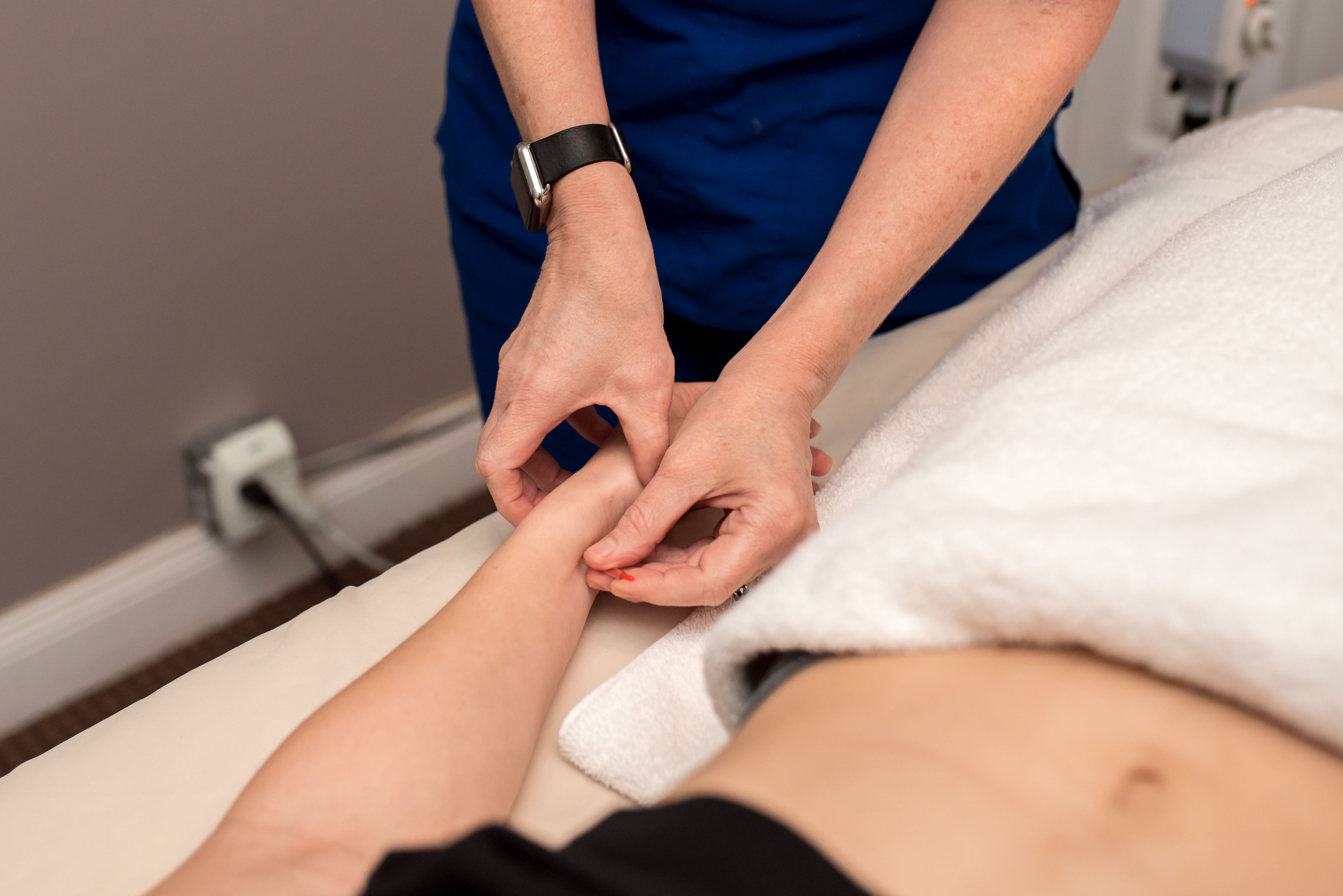 Acupuncture Physician treating a point on a patient's hand at Health Pointe Jacksonville