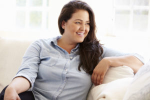 Smiling woman relaxing on a sofa at home