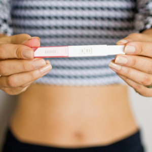 Woman holding a positive home pregnancy test