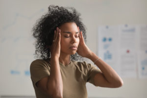Woman pressing both temples with her fingers during a headache