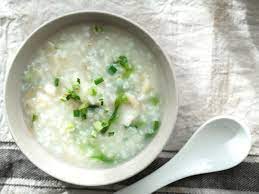 Bowl of Chinese congee rice porridge topped with spring onions